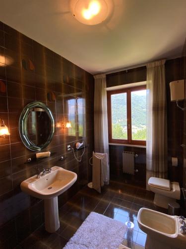 łazienka z umywalką i lustrem w obiekcie B&B Rox e Claudia w mieście Lugnola