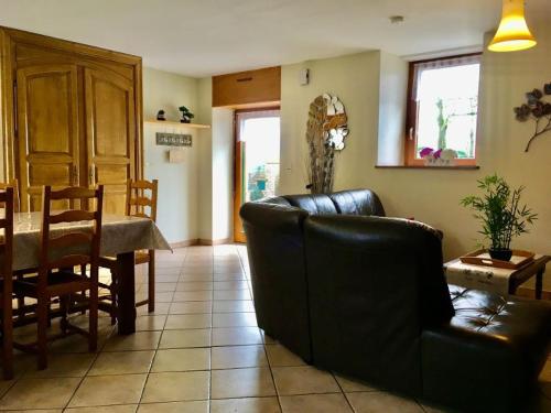 un salon avec un canapé et une table ainsi qu'une salle à manger dans l'établissement Gite, à Saint-Denoual