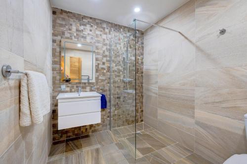 ein Bad mit einer Glasdusche und einem Waschbecken in der Unterkunft Modern 1BR Apartment in central St Julian's in St Julian's