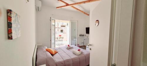 1 dormitorio con cama con sábanas rosas y ventana en Incanto barocco en Ragusa