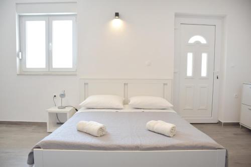 a white bedroom with two pillows on a bed at Studio apartman Gili in Kaštela