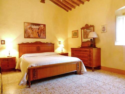 um quarto com uma cama, uma cómoda e uma janela em Agriturismo Fattoria Il Piano - Appartamento Antica Cucina - San Gimignano em San Gimignano