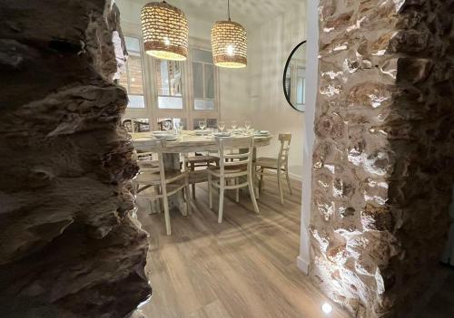a dining room with a table and a stone wall at Arrels apartaments in L'Ampolla