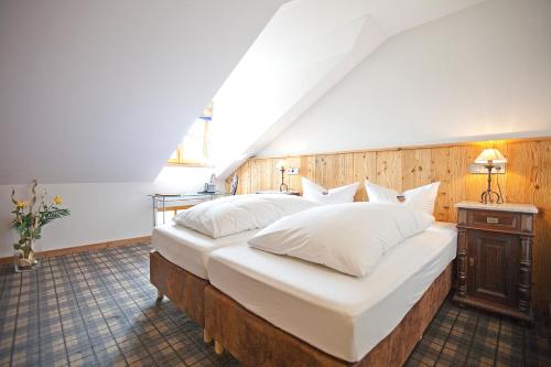Un dormitorio con dos camas con almohadas blancas. en DIE POST Landgasthof Aufkirchen, en Berg am Starnberger See