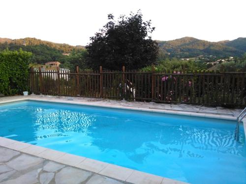 a swimming pool with blue water in front of a fence at Gîte La nonnette in Prades