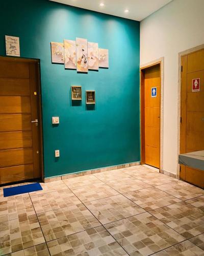 a room with a blue wall with pictures on it at SÍTIO MARAVILHOSO EM MAIRIPORÃ opção de 1 quarto para 8 pessoas ou 4 quartos acima de 9 pessoas in Mairiporã