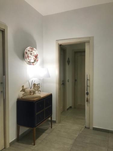 a room with a table with a lamp and a hallway at International Naples in Naples