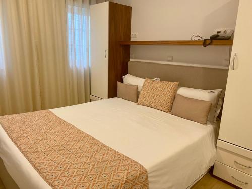
a hotel room with a bed and a dresser at Hotel Neptuno in Peniche
