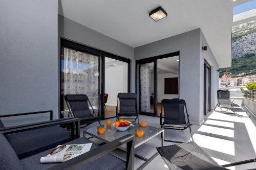 a living room with a table and chairs on a balcony at Laurus Makarska Accommodation in Makarska