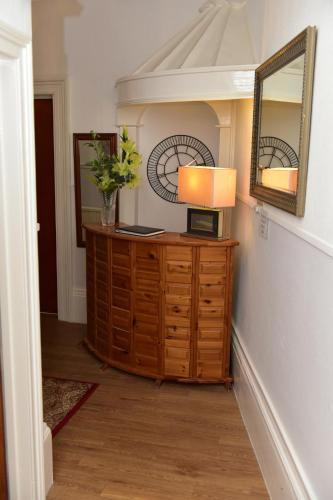 a room with a lamp on a dresser with a mirror at CORBIERE GUEST HOUSE in Weston-super-Mare