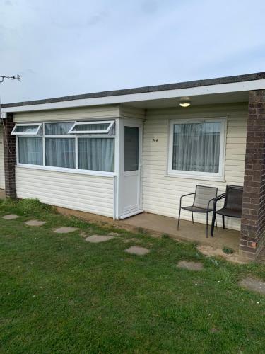 a house with a porch with a chair on a patio at bulldog holidays 244 in Hemsby