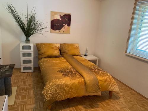 a bedroom with a bed with a yellow comforter at Schönes Apartment mit Terrasse, mitten im Grünen Stattegg in Stattegg