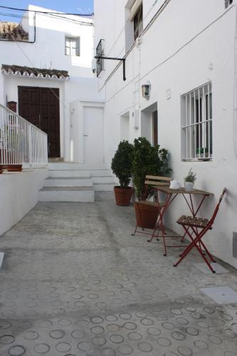 a courtyard of a white building with a table and chairs at La Moradita in Vejer de la Frontera