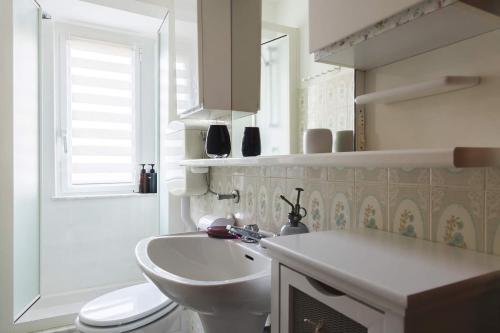 a white bathroom with a sink and a toilet at La Casetta di Giorgia in Fenis