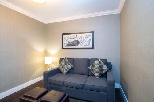 a living room with a blue couch in a room at Sandman Hotel Vancouver Airport in Richmond