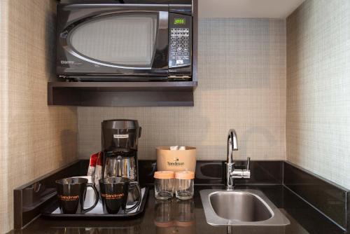 a kitchen counter with a coffee maker and a microwave at Sandman Hotel Vancouver Airport in Richmond