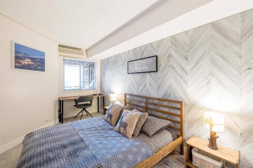 a bedroom with a bed and a desk at 1BR plus Den Village Condo with Mountain Views and Hot Tub by Harmony Whistler in Whistler