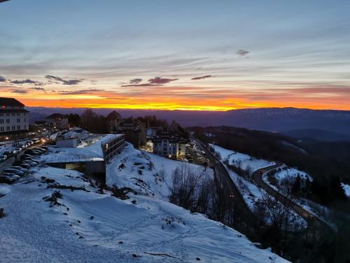a view of a city in the snow at sunset at Sunset View Ski & Spa apartments Kopaonik in Kopaonik