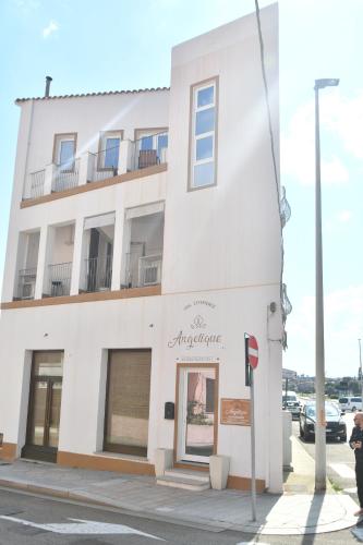 a white building with a sign on the side of it at Angelique Affittacamere in Santa Teresa Gallura