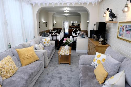 a living room with two couches and a kitchen at Toulson Court in Scarborough