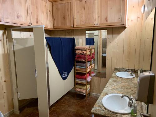 Un baño con dos lavabos y armarios de madera. en Lodge on Lake Godstone, en Jacksboro