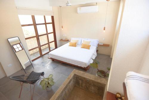 een slaapkamer met een bed, een tafel en een spiegel bij La Casa del Totumo in Santa Marta