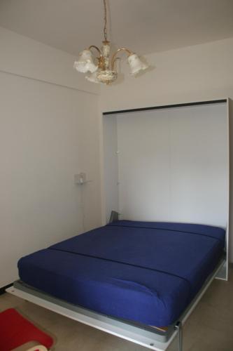 ein blaues Bett in einem Zimmer mit einer Decke in der Unterkunft Casa Paggi in Lavagna