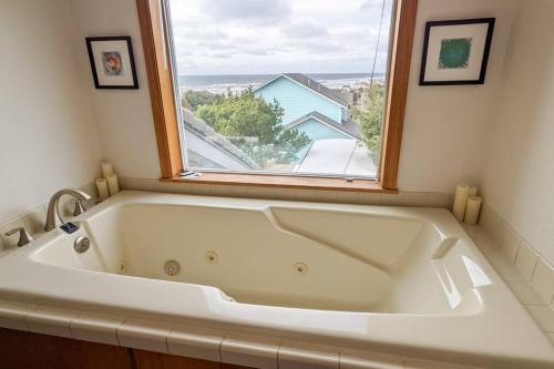 W łazience z oknem znajduje się biała wanna. w obiekcie NEW Large Beach Getaway: 3 King bedroom suites! w mieście Florence