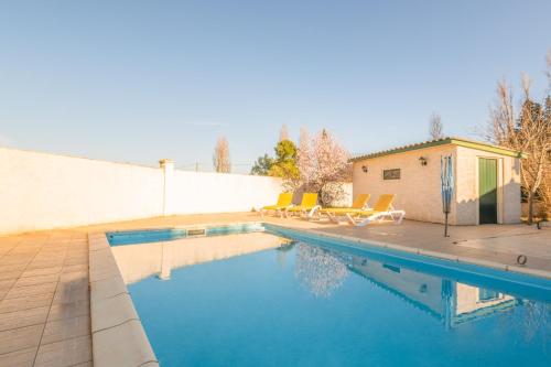 - une piscine avec des chaises à côté d'un mur dans l'établissement Maison des papillons, à Ouveillan