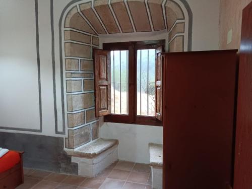 een kamer met een raam en een bakstenen muur bij Casa Castell in Castellfort