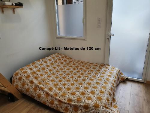 - un lit dans une chambre avec couverture dans l'établissement Angers Green Lodge - Cosy Studio, à Angers