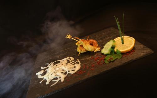 a plate of food with noodles and an orange slice at Berghotel Hois in Heiligenblut