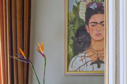 een schilderij van een vrouw en een kat op een muur bij House of Frames in Milaan