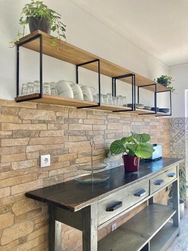 a wooden table with shelves on a brick wall at The Globetrotter's Inn in Ericeira
