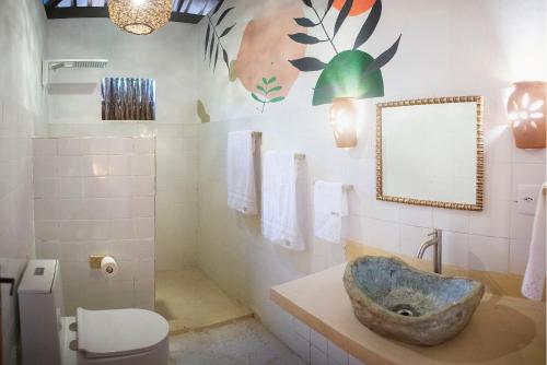 a bathroom with a sink and a toilet at Casa Alegre Trancoso, piscina, 3 suítes e ar-cond. in Trancoso