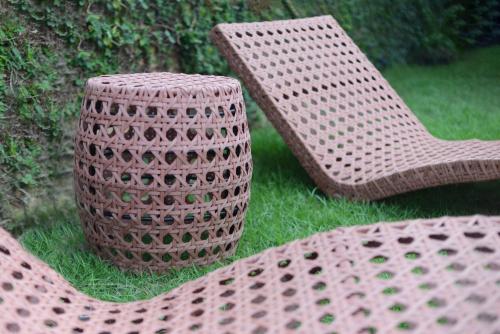 two wicker chairs and a vase in the grass at Casa Alegre Trancoso, piscina, 3 suítes e ar-cond. in Trancoso