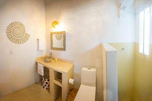 a bathroom with a sink and a toilet at Casa Alegre Trancoso, piscina, 3 suítes e ar-cond. in Trancoso