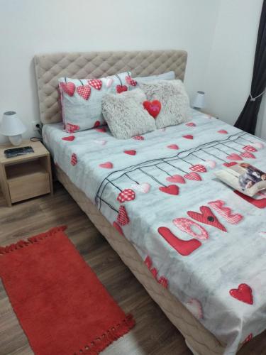 a bedroom with a bed with red hearts on it at Apartman Cer in Banja Koviljača