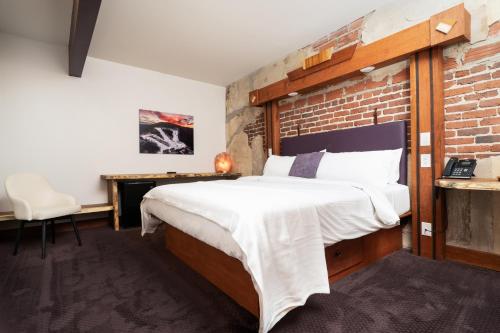 a bedroom with a bed and a brick wall at The Horton Hotel in Boone