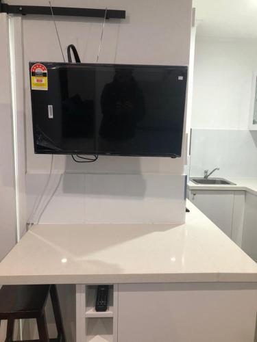 telewizor z płaskim ekranem siedzący na blacie w obiekcie St Kilda Lovely Studio Apartment w Melbourne