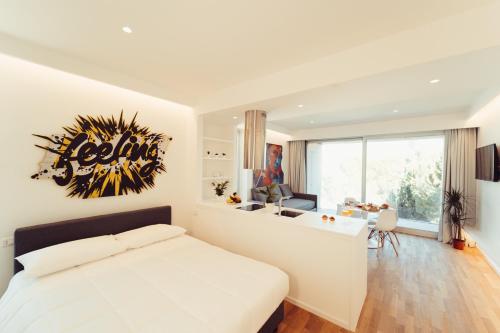 a white bedroom with a large bed and a desk at Marina Gardens Boutique&Suites in Francavilla al Mare