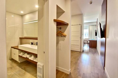 a bathroom with a sink and a mirror and a counter at Hôtel Le Navigateur in Rimouski