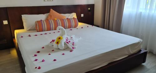 Una cama con un conejito hecho de flores encima. en Ocean Villas Apart Hotel by Ocean Hospitality, en Grand Baie