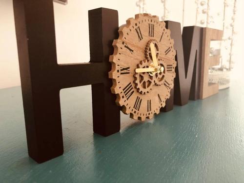 a wooden clock sitting next to a letter h at The Villas - Modern Comfort, 15 mins to Silverstone and Milton Keynes - Free parking, Prime, Netflix in Buckingham