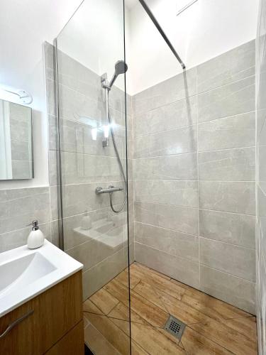 a bathroom with a shower and a sink at La plume dorée - Hotel de ville in Saint Etienne
