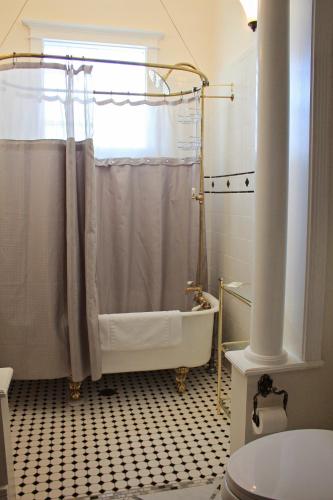 a bathroom with a bath tub and a shower curtain at Bowen Motel in Moab