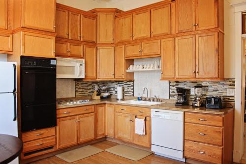 a kitchen with wooden cabinets and white appliances at Bowen Motel in Moab