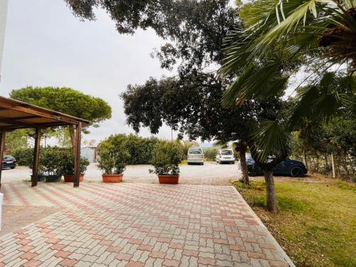 a brick driveway with potted plants and a pavilion at Il Tombolo in Giannella