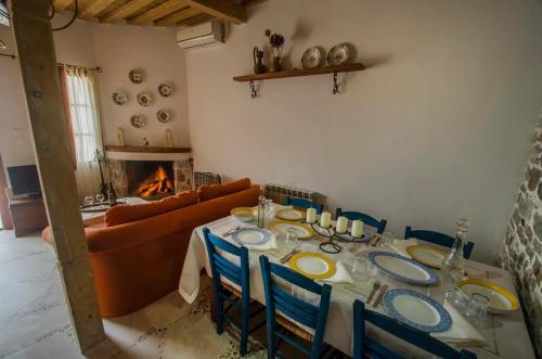 een eetkamer met een tafel, een bank en een open haard bij Anastasia's Home in Émbonas