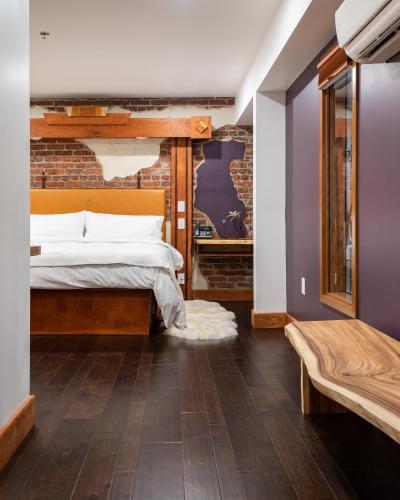 a bedroom with a bed and a brick wall at The Horton Hotel in Boone